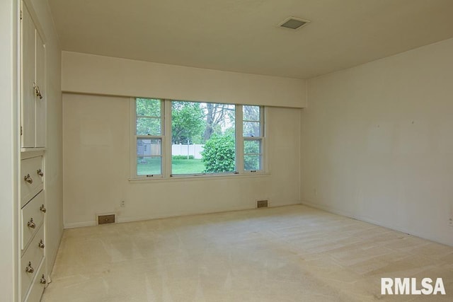 empty room with carpet floors and visible vents