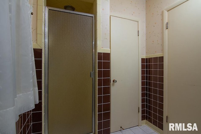 full bathroom with tile patterned floors, wallpapered walls, and a shower stall