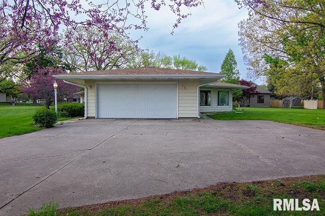 ranch-style house with a detached garage and a front lawn