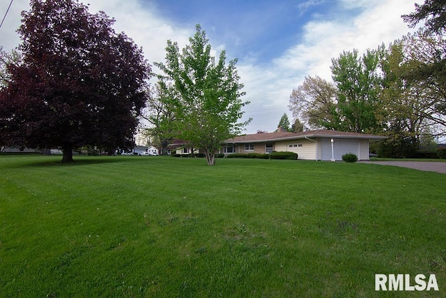 view of front facade featuring aphalt driveway, a garage, and a front lawn