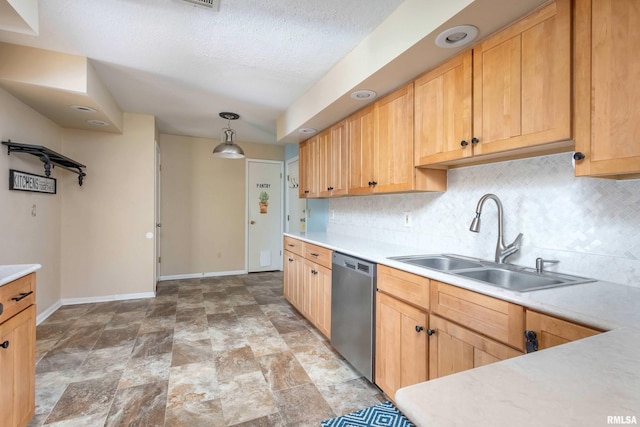 1360 Kimberly Ridge Rd Unit 309, Bettendorf, IA 52722 - kitchen with a sink, stainless steel dishwasher, baseboards, light countertops, and decorative backsplash