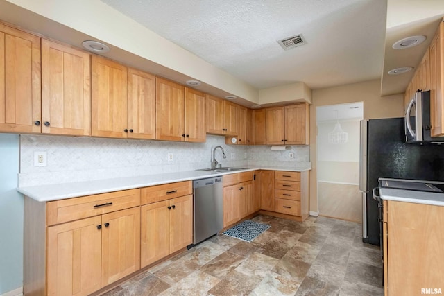 1360 Kimberly Ridge Rd Unit 309, Bettendorf, IA 52722 - kitchen featuring a sink, stainless steel appliances, visible vents, light countertops, and decorative backsplash