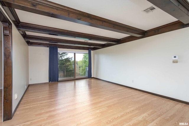 1360 Kimberly Ridge Rd Unit 309, Bettendorf, IA 52722 - spare room featuring light wood-style floors, visible vents, baseboards, and beamed ceiling