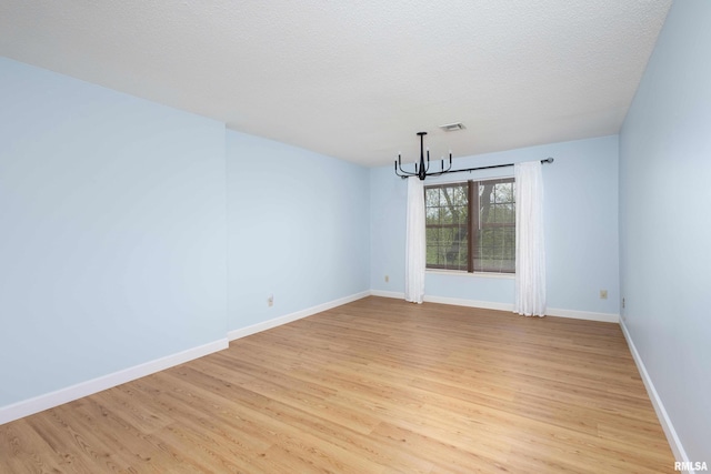 1360 Kimberly Ridge Rd Unit 309, Bettendorf, IA 52722 - unfurnished dining area featuring baseboards, light wood finished floors, a chandelier, and visible vents