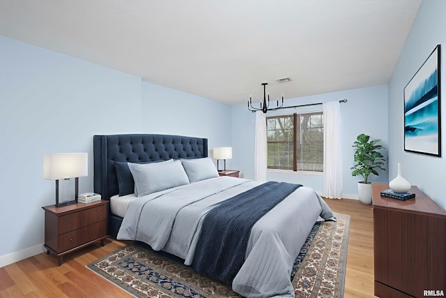 1360 Kimberly Ridge Rd Unit 309, Bettendorf, IA 52722 - bedroom with a chandelier, light wood-style flooring, and baseboards