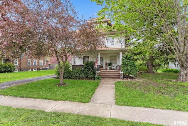 view of front of property with a front lawn, brick siding, and covered porch