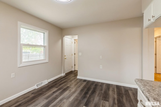 interior space featuring dark wood-style flooring, baseboards, and visible vents