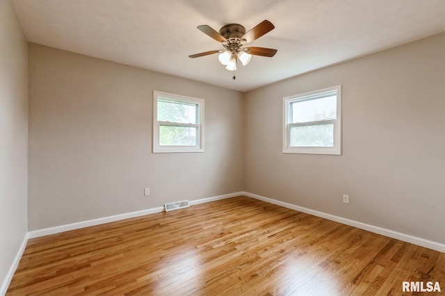 empty room with light wood-style flooring, baseboards, and visible vents