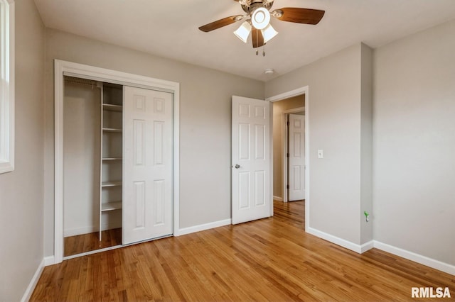 unfurnished bedroom featuring a closet, light wood-type flooring, baseboards, and ceiling fan