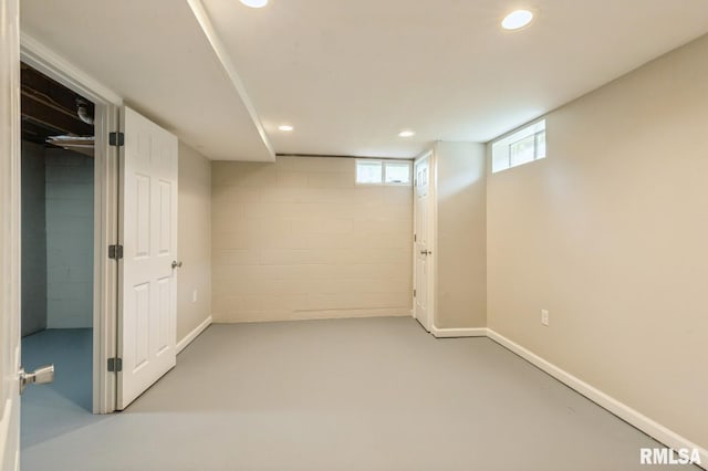 basement featuring concrete block wall, baseboards, and recessed lighting