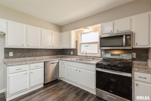 kitchen with white cabinets, stainless steel appliances, dark wood-style flooring, and a sink