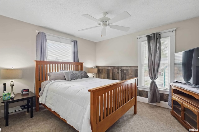 bedroom with light colored carpet, a ceiling fan, and multiple windows