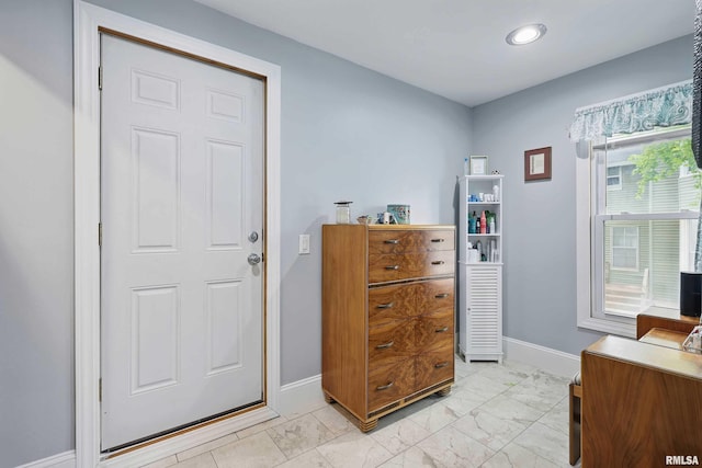 foyer featuring baseboards, marble finish floor, and recessed lighting