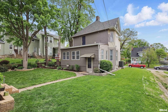 exterior space featuring central AC unit, a chimney, roof with shingles, and a lawn