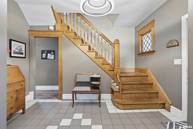 stairs with baseboards and tile patterned floors