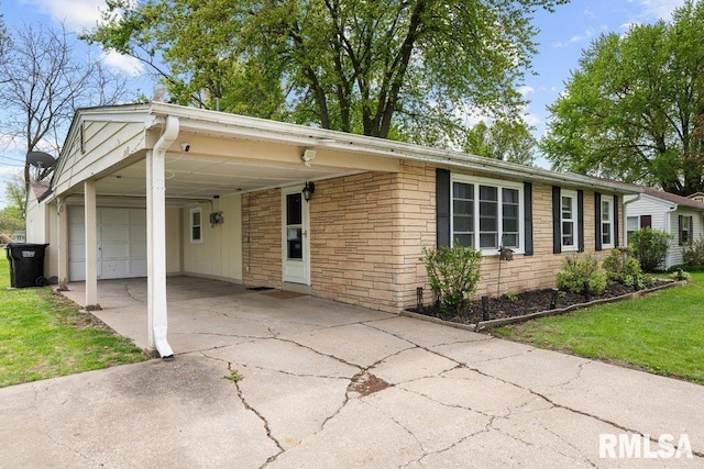 ranch-style home featuring concrete driveway, a front yard, an attached carport, and a garage