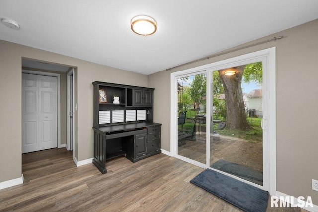 doorway to outside featuring baseboards and light wood-style floors