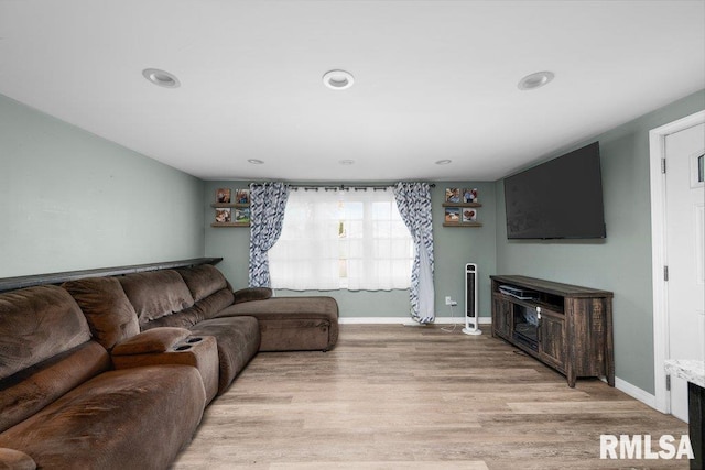 living room featuring baseboards, light wood-type flooring, and recessed lighting