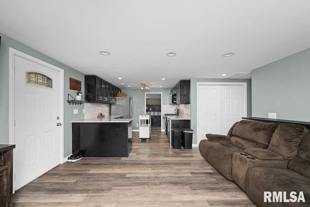 living area with recessed lighting, baseboards, and wood finished floors