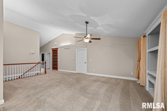 interior space with a ceiling fan, carpet floors, a textured ceiling, visible vents, and lofted ceiling