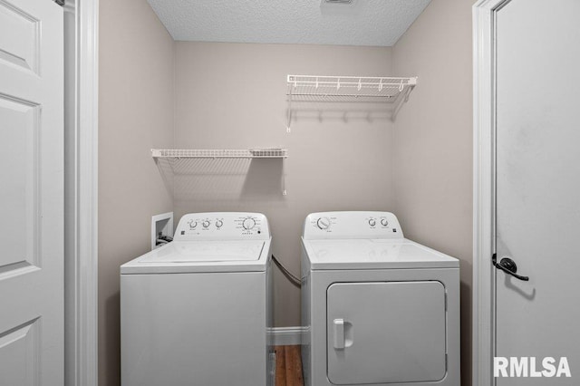 laundry area with laundry area, a textured ceiling, and washer and clothes dryer