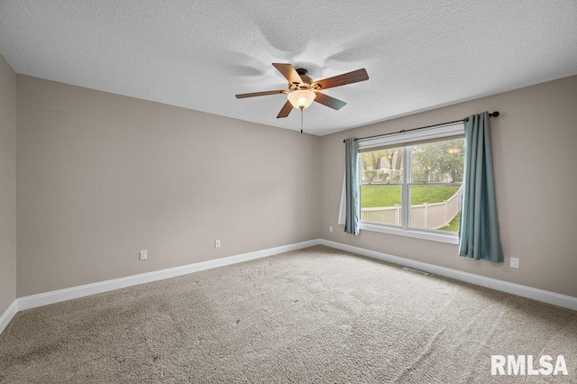 carpeted empty room with a ceiling fan, baseboards, and visible vents