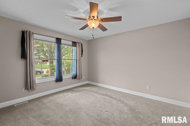 carpeted empty room with ceiling fan, a textured ceiling, baseboards, and visible vents