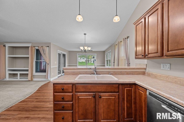 kitchen featuring a peninsula, an inviting chandelier, a sink, open floor plan, and stainless steel dishwasher