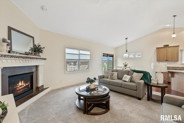 17 Blackstone Way, Le Claire, IA 52753 - living room featuring vaulted ceiling, light colored carpet, and a glass covered fireplace