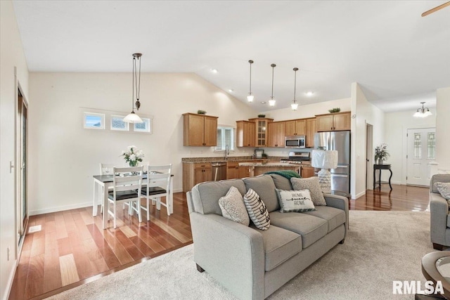 17 Blackstone Way, Le Claire, IA 52753 - living room with light wood-style flooring, vaulted ceiling, healthy amount of natural light, and baseboards