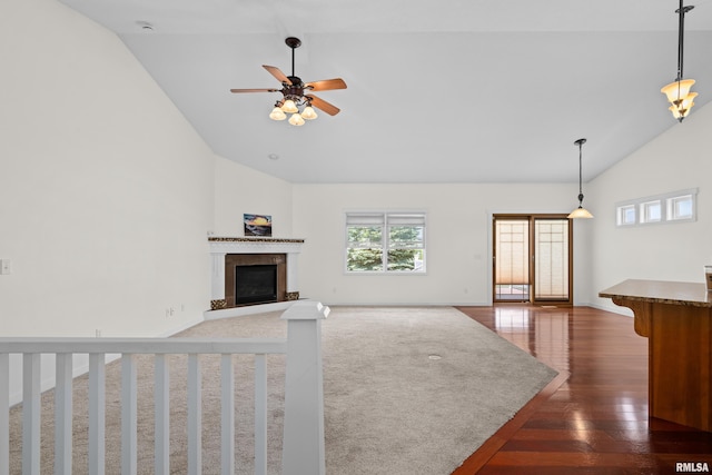 17 Blackstone Way, Le Claire, IA 52753 - unfurnished living room with a glass covered fireplace, high vaulted ceiling, dark wood-style flooring, a ceiling fan, and baseboards