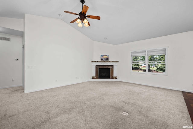 17 Blackstone Way, Le Claire, IA 52753 - unfurnished living room featuring vaulted ceiling, ceiling fan, carpet flooring, a tile fireplace, and baseboards