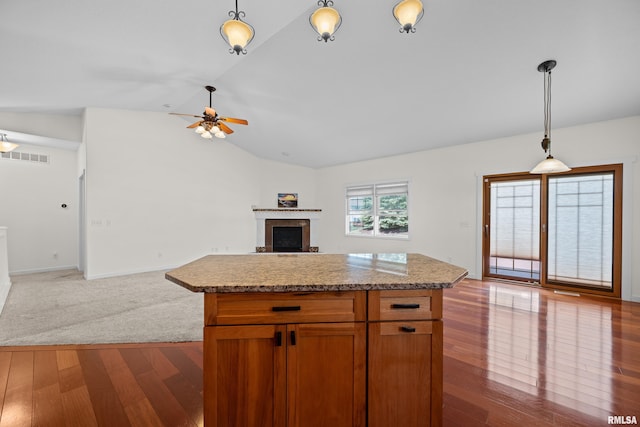 17 Blackstone Way, Le Claire, IA 52753 - kitchen with open floor plan, vaulted ceiling, a ceiling fan, a fireplace, and wood finished floors