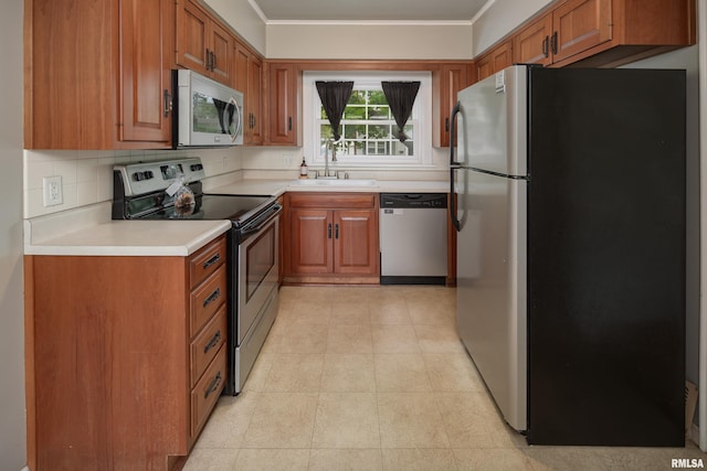 kitchen with brown cabinetry, stainless steel appliances, crown molding, and a sink