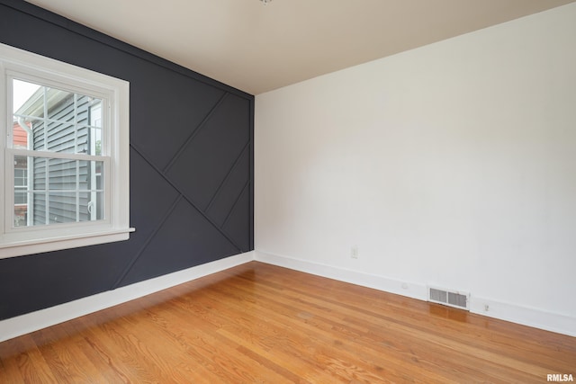 spare room featuring visible vents, baseboards, and light wood-style flooring