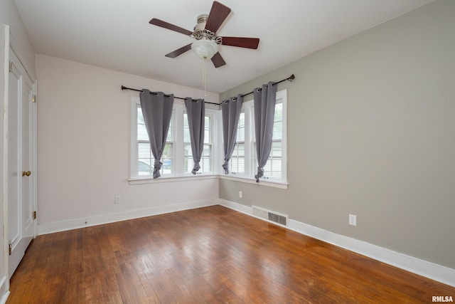 unfurnished room with baseboards, wood-type flooring, visible vents, and a ceiling fan
