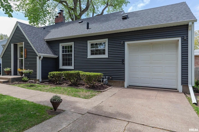 view of front facade featuring a chimney, driveway, a shingled roof, and a garage