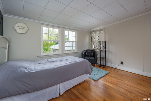 bedroom featuring crown molding and wood finished floors
