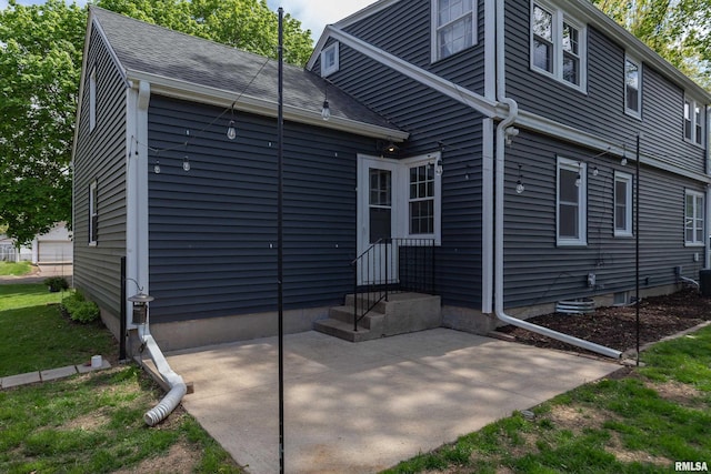 back of house featuring a patio area and a shingled roof