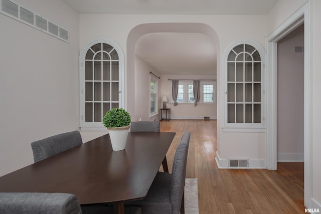 dining room with baseboards, visible vents, and wood finished floors