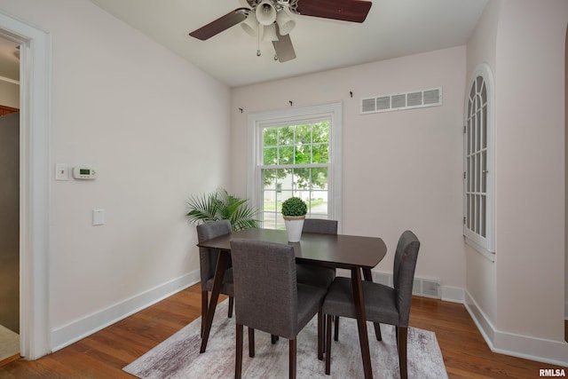 dining area with baseboards, ceiling fan, visible vents, and wood finished floors