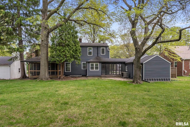 back of property with a sunroom, a lawn, central air condition unit, and a chimney