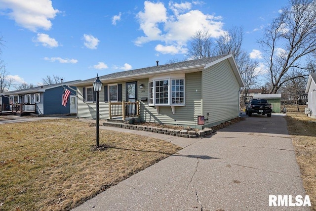 single story home featuring concrete driveway and a front yard