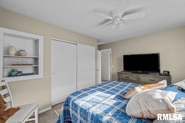carpeted bedroom featuring ceiling fan, a closet, and baseboards
