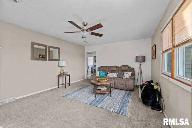 living area featuring a ceiling fan, carpet flooring, visible vents, and a textured ceiling
