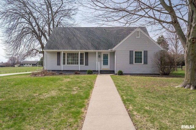 view of front of home featuring a front yard and roof with shingles