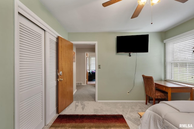 carpeted bedroom featuring a closet, baseboards, and a ceiling fan