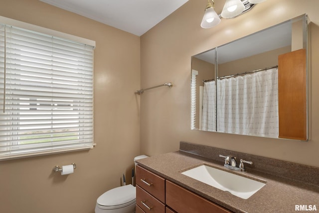 full bath featuring toilet, vanity, and a shower with curtain