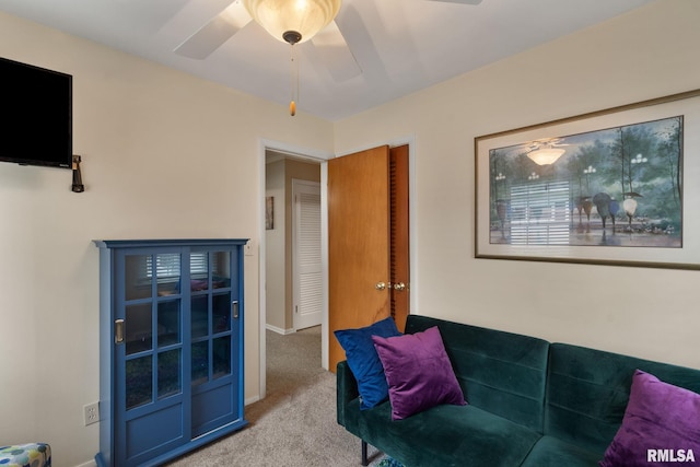 carpeted living area with a ceiling fan