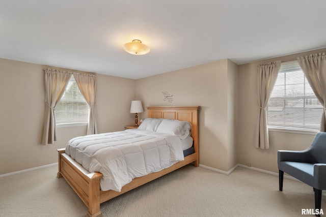 bedroom featuring multiple windows, light carpet, and baseboards